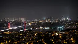 Pemandangan malam Jembatan Martir 15 Juli atau yang lebih dikenal dengan Jembatan Bosphorus di Istanbul, Turki, Jumat (24/8). Jembatan Bosphorus merentang di atas Selat Bosporus. (OZAN KOSE/AFP)