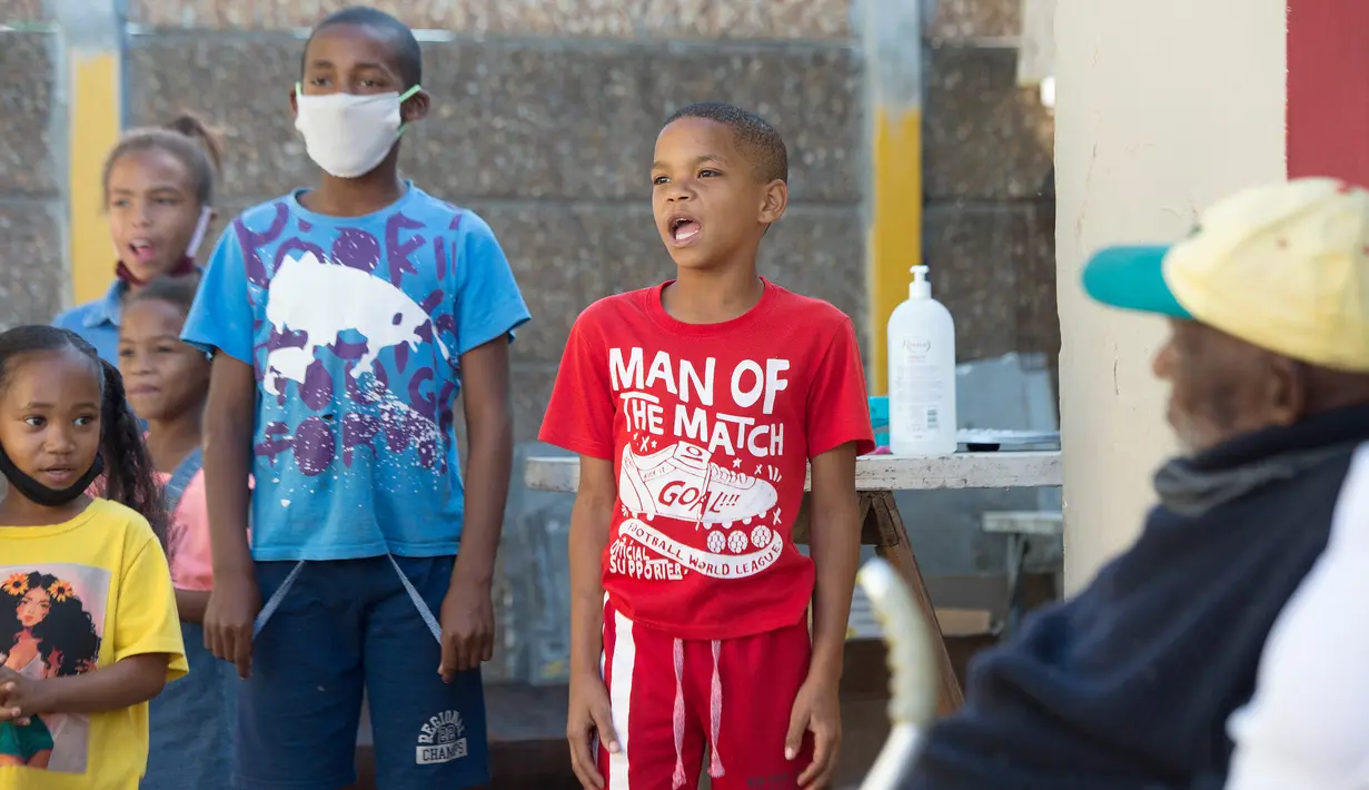 Anak-anak menyanyikan Selamat Ulang Tahun untuk Fredie Blom ketika merayakan ulang tahun ke 116 di rumahnya di Delft, dekat Cape Town, 8 Mei 2020. Menurut 'Oupa' (kakek) Fredie dan kartu identitasnya, ia lahir pada tahun 1904 yang menjadikannya salah satu pria tertua di dunia. (RODGER BOSCH/AFP)