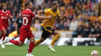 Gelandang Liverpool, Alexis Mac Allister (kiri) berusaha mengadang laju striker Wolverhampton Wanderers, Matheus Cunha pada laga pekan kelima Premier League 2023/2024 di Molineux Stadium, Wolverhampton, Sabtu (16/9/2023) malam WIB. (AFP/Adrian Dennis)