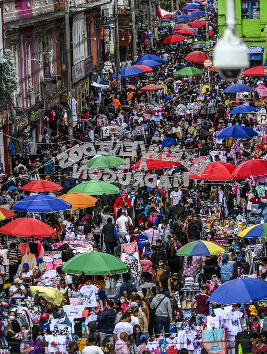 Kepadatan jalan komersial di San Victorino saat orang-orang berbelanja hadiah Natal di Bogota, Kolombia, Senin (21/12/2020). Kota-kota utama di Kolombia pada Senin mengumumkan pembatasan yang mempengaruhi sekitar 15 juta orang karena peningkatan penularan covid-19 menjelang Natal. (Juan BARRETO/AFP)