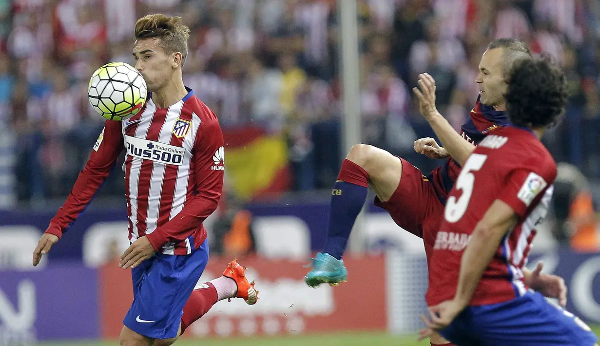 Andres Iniesta berusaha menghentikan pemain Atletico, Antoine Griezmann (kiri) dalam lanjutan La Liga Spanyol di Stadion Vicente Calderon, Madrid, Spanyol. Sabtu (12/9/2015). (EPA/Zipi)
