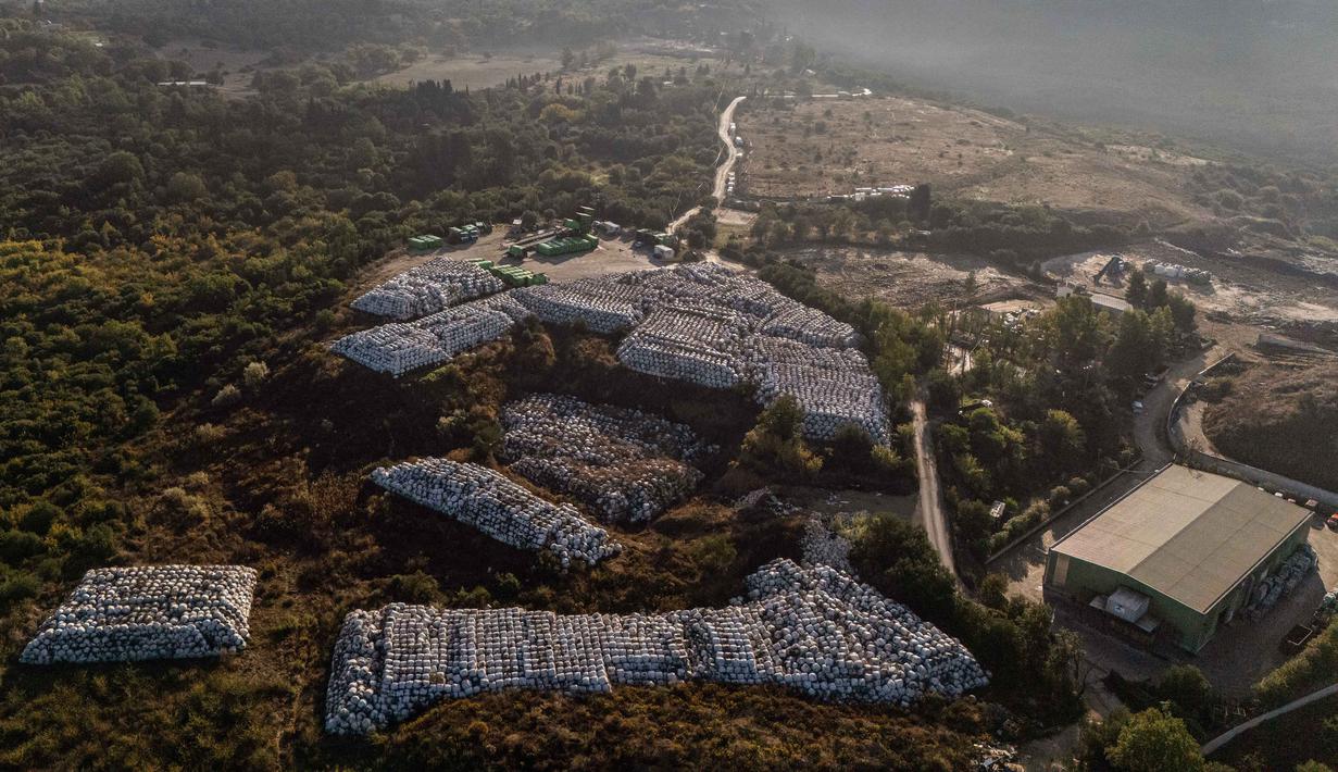 Pulau Corfu berada di Laut Ionia, Yunani, menghadapi masalah pengelolaan sampah. Hal ini dikarenakan, pemerintah kota hanya memiliki satu tempat pembuangan sampah yang mulai penuh. Tampak sebuah foto udara memperlihatkan ratusan bal-bal sampah yang dibungkus plastik disimpan di samping pabrik daur ulang di kota Pulau Corfu pada tanggal 15 Oktober 2025. (Angelos TZORTZINIS/AFP)