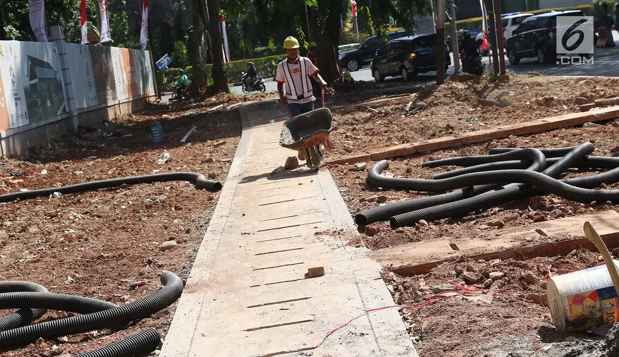 Pekerja menyelesaikan pembuatan trotoar di kawasan Senayan, Jakarta, Senin (28/8). Pembuatan trotoar dilakukan dalam rangka menyambut event Asian Games 2018 mendatang yang akan digelar di Jakarta dan Palembang. (Liputan6.com/Immanuel Antonius)