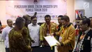 Sekjen Partai Hanura Harry Lontung Siregar (dua kanan) menyerahkan berkas pendaftaran bakal calon legislatif kepada Komisioner KPU Hasyim Asy'ari (dua kiri) di KPU, Jakarta, Selasa (17/7). (Liputan6.com/JohanTallo)