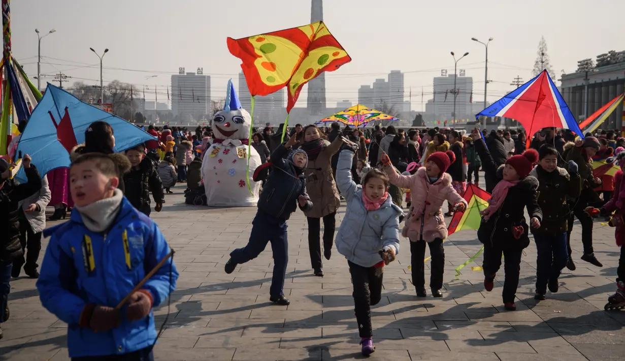 Sejumlah anak bermain layang-layang saat merayakan hari libur Tahun Baru Imlek di alun-alun Kim Il Sung di Pyongyang, Korea Utara (16/2). Dalam perayaan Imlek di Korea Utara ini tidak terlihat ornamen dan aksesoris khas Tionghoa. (AFP Photo/Kim Won-Jin)