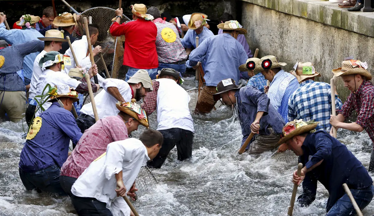 Para Nelayan berjuang untuk mendapatkan ikan saat hari nelayan di Memmingen, Jerman, Sabtu (25/7/2015). Peserta yang menangkap ikan terbesar akan diberi nama "Raja Nelayan" selama satu tahun. (REUTERS/Michaela Rehle)