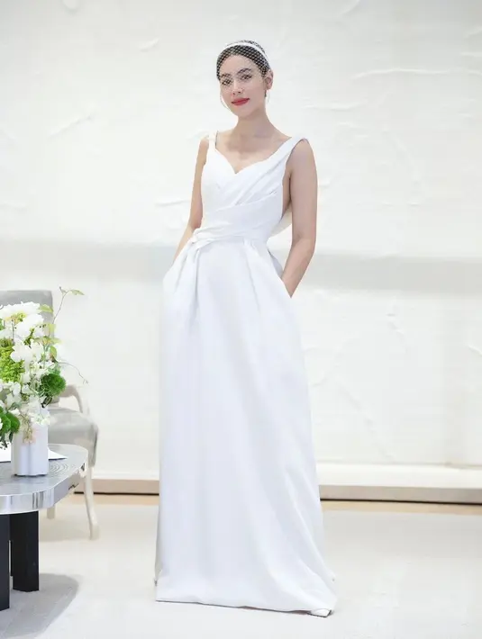 Gaun kedua hadir dengan garis leher lipit yang sangat halus, dibedakan dengan garis-garis ramping dan kontemporer yang memeluk pinggang dengan elegan. [Dok/Dior]