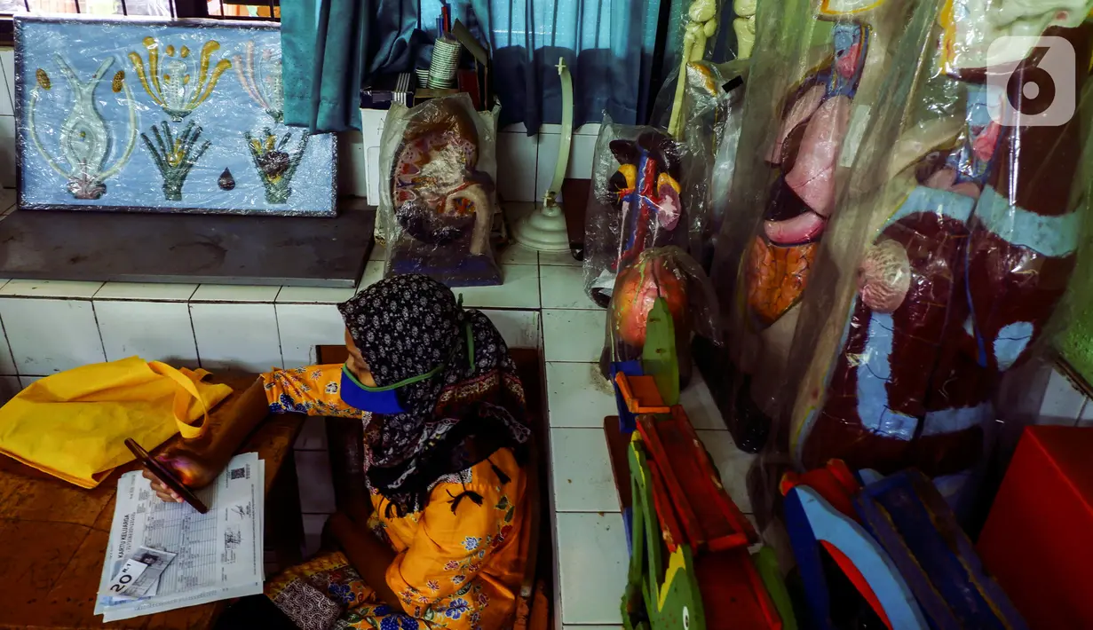 Warga penerima manfaat menunggu giliran saat pencairan bantuan sosial tunai (BST) di SDN Kembangan Utara 05 Pagi, Jakarta, Rabu (31/3/2021). Program BST sebesar Rp300 ribu dari Kemensos ini disalurkan melalui RT-RT se kelurahan Kembangan Utara melalui ATM Bank DKI. (Liputan6.com/Johan Tallo)