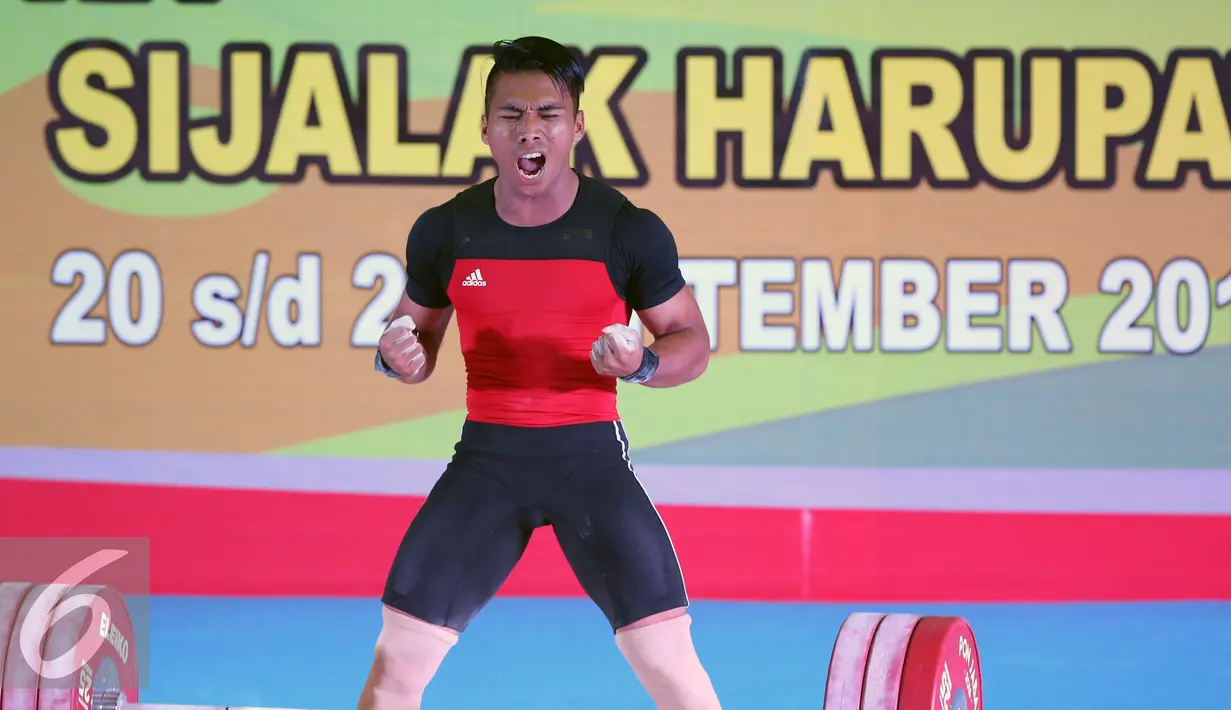 Lifter Jawa Barat, Deni melambaikan tangan usai mengangkat beban 183kg clean and jerk kelas 69kg PON XIX Jabar di Gymnasium Si Jalak Harupat, Kab Bandung, Rabu (21/9). Deni meraih emas dengan total angkatan 328kg. (Liputan6.com/Helmi Fithriansyah)