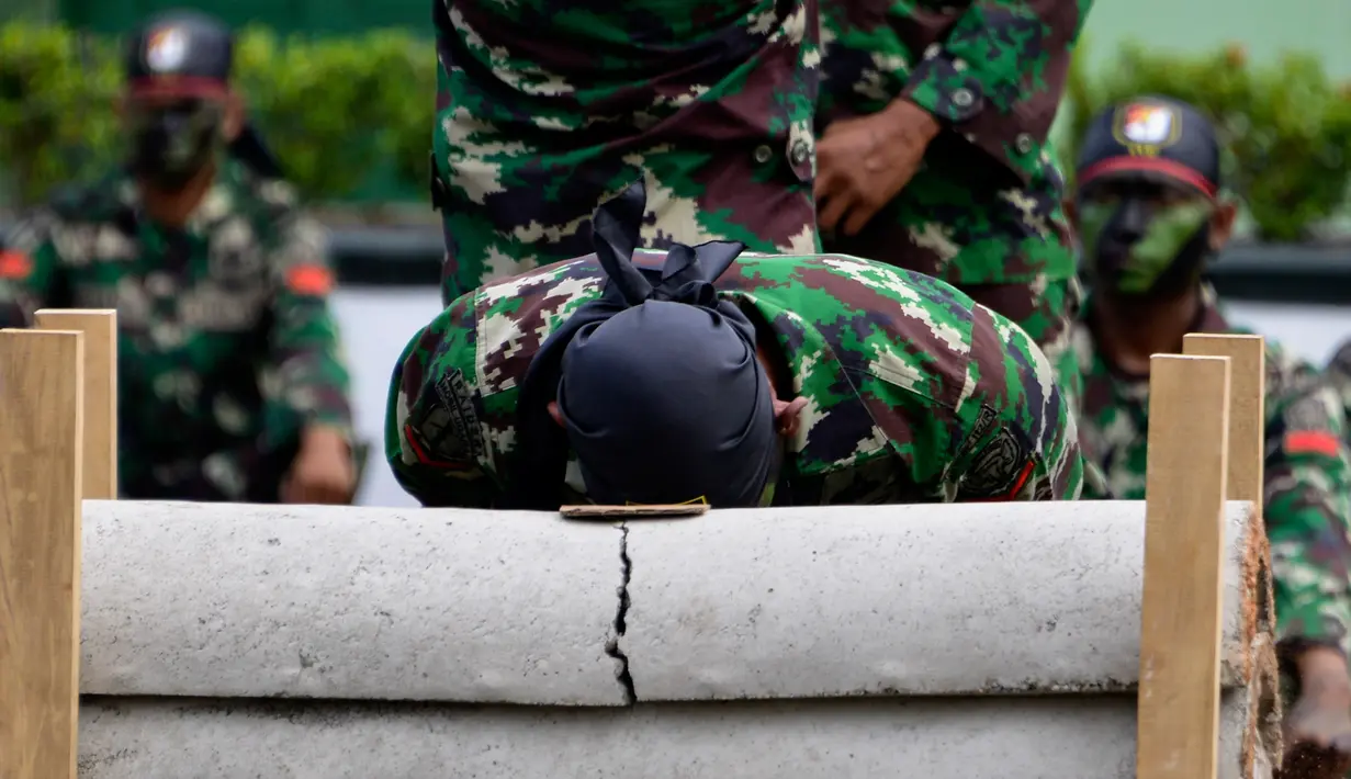 Prajurit TNI Yonif Raider 112/Dharma Jaya mematahkan pipa beton dengan kepalanya saat atraksi dalam upacara sertijab di Banda Aceh, Aceh, Rabu (18/9/2019). Mayor Inf Syarifuddin Liwang menjadi Komandan Yonif Raider 112/Dharma Jaya menggantikan Mayor Inf Agus Alfauzi. (CHAIDEER MAHYUDDIN/AFP)