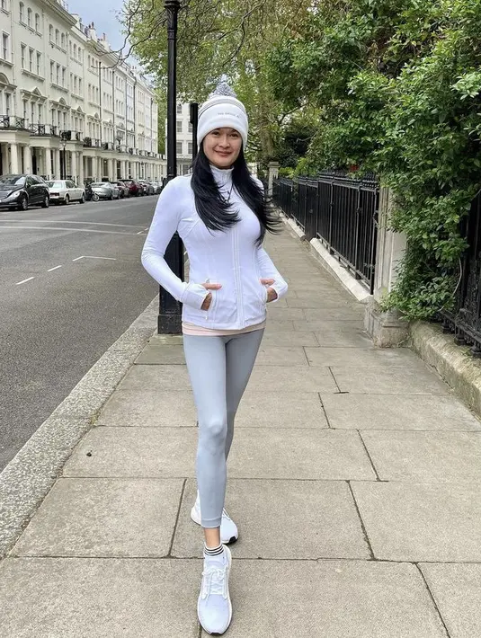 Donna juga tampil sporty mengenakan jaket track putih yang dikombinasikan celana legging dan sneaker putih. Ia melengkapi penampilanya dengan bennie. (@donnaharunofficial)