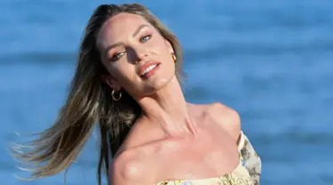 Model Afrika Selatan Candice Swanepoel berpose saat sesi pemotretan di pantai Lido menjelang pembukaan Festival Film Venesia ke-76 di Venice Lido, Italia (27/8/2019). Candice tampil cantik mengenakan blus  hijau bermotif bunga dan jeans biru ketat dengan rambut pirangnya yang terurai. (AFP Photo/Alb