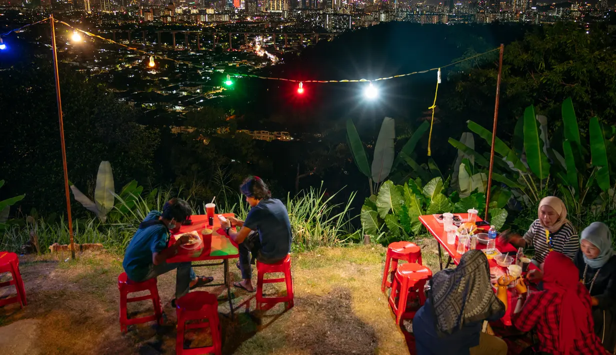 Sejumlah orang bersantap malam di warung makan kaki lima, Kuala Lumpur, Malaysia, 24 Agustus 2020. Kombinasi antara gedung pencakar langit dan situs bersejarah serta perpaduan harmonis beragam budaya semakin memperkaya pesona khas dari Kuala Lumpur. (Xinhua/Zhu Wei)