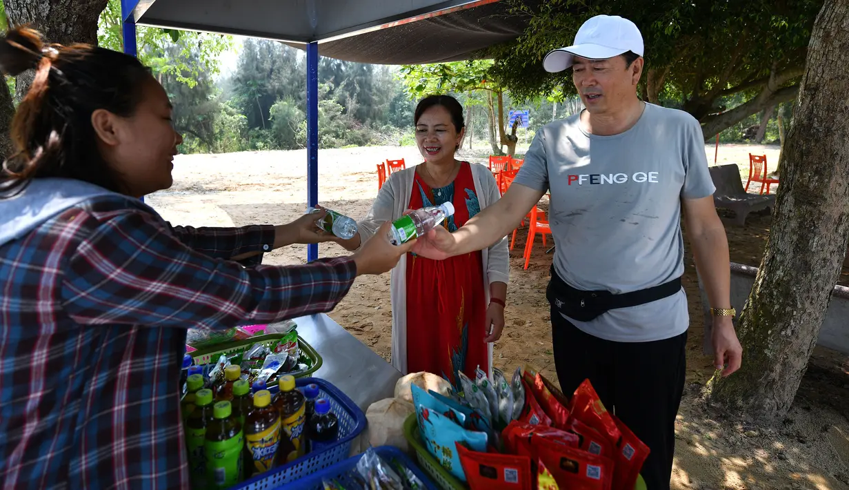 Sejumlah turis menukarkan sampah dengan dua botol air kemasan di Teluk Mulan, Kota Wenchang, Provinsi Hainan, China, 28 April 2020. (Xinhua/Guo Cheng)