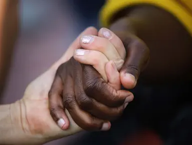 Orang-orang bergandengan tangan saat demonstrasi memprotes kematian George Floyd di Barcelona, ​​Spanyol, Kamis (4/6/2020). George Floyd, seorang pria kulit hitam meninggal setelah ditahan oleh petugas kepolisian Minneapolis pada 25 Mei. (AP Photo/Emilio Morenatti)