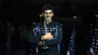 Petenis Serbia, Novak Djokovic memegang trofi AS Terbuka setelah mengalahkan Juan Martin del Potro pada partai final di New York, Minggu (9/9). Gelar ini adalah yang keempat di AS Terbuka sejak yang terakhir pada 2015. (MATTHEW STOCKMAN/GETTY IMAGES/ AFP)