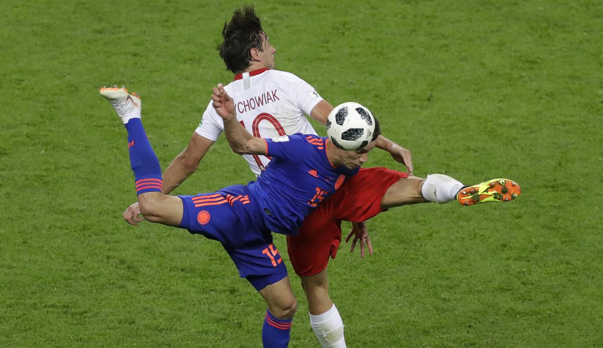 Gelandang Kolombia, Mateus Uribe, berebut bola dengan gelandang Polandia, Grzegorz Krychowiak, pada laga grup H Piala Dunia di Kazan Arena, Kazan, Minggu (24/6/2018). Kolombia menang 3-0 atas Polandia. (AP/Sergei Grits)