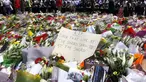 Sejumlah orang berdiri di balik pembatas tumpukan bunga di dekat Kafe Lindt, Sidney, Australia (16/12/2014). (REUTERS/David Gray)