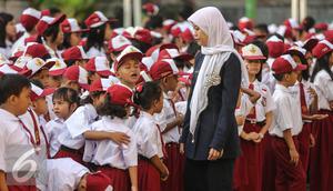 Guru mengatur para murid sebelum upacara di SD Pasar Baru 05, Jakarta, Senin (27/7/2015). Usai libur panjang Idul Fitri para siswa kembali beraktivitas mengikuti pelajaran di sekolah untuk tahun ajaran 2015-2016. (Liputan6.com/Faizal Fanani)