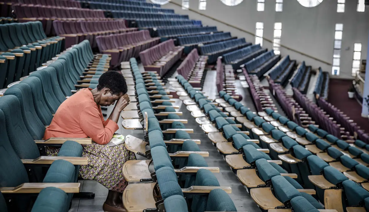 Seorang perempuan berdoa untuk mengakhiri pandemi Virus Corona sambil duduk sendirian di sebuah gereja yang kosong saat menyiarkan khotbah secara online di Nairobi Baptist Church di Nairobi, Kenya pada 22 Maret 2020 . (Photo by LUIS TATO / AFP)