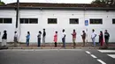 Para pemilih mengenakan masker saat antre di luar tempat pemungutan suara di Kolombo, Sri Lanka, Rabu (5/8/2020). Sri Lanka menggelar pemilihan parlemen di tengah pandemi COVID-19. (Ishara S. KODIKARA/AFP)