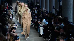 Halima Aden bersama model lainnya berjalan mengenakan koleksi Max Mara women's Fall/Winter 2017-2018 pada Milan Fashion Week, di Milan, Kamis (23/2). Bahkan Halima Aden disejajarkan dengan model yang sedang naik daun, Gigi Hadid. (Miguel MEDINA/AFP)