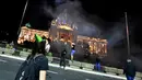Pengunjuk rasa yang dengan pemberlakuan kembali jam malam Covid-19 pada akhir pekan berdiri di depan gedung Majelis Nasional di Beograd, Selasa (7/7/2020). Bentrokan terjadi antara polisi Serbia dan sekelompok demonstran yang menyerbu gedung parlemen. (OLIVER BUNIC/AFP)