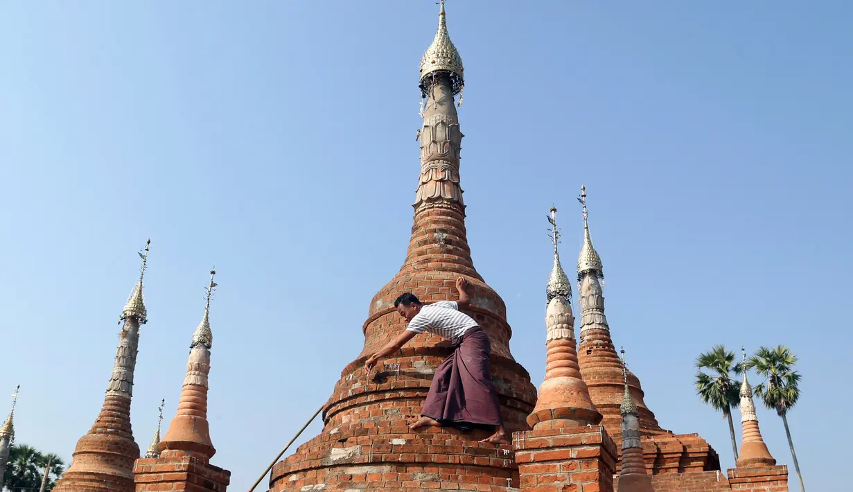 Relawan menyapu pagoda Buddha kuno di Naypyitaw, Myanmar (27/1). Pagoda yang berada di ibu kota negara tersebut dibangun 160 tahun lalu pada masa dinasti Konbaung dan Amarapura. (AP Photo/Aung Shine Oo)