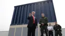 Presiden AS, Donald Trump berbincang saat melihat prototipe tembok perbatasan AS dan Meksiko yang kontroversial di San Diego, Selasa (13/3). Untuk membangun tembok ini, Trump sudah mengajukan anggaran sebesar US$18 miliar kepada Kongres. (AP/Evan Vucci)