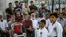 Anggota keluarga menyaksikan anak-anaknya berlatih karate selama upacara promosi Karate di pusat olahraga di kamp Rafah untuk para pengungsi Palestina di Jalur Gaza selatan (20/9/2019). (AFP Photo/Said Khatib)