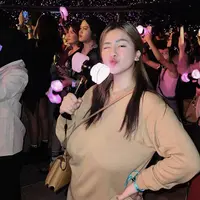Sambil membawa light stick, Felicya tampil dengan atasan lengan panjang yang serasi dengan sling bagnya.  (@felicyangelista_)