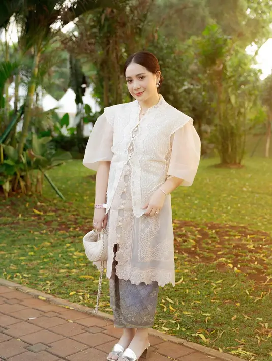 Nagita memilih style layering, dari dress panjang bernuansa earthtone berbahan organza yang memiliki detail bordiran yang indah, dipadukan vest kebaya warna putih. [Instagram/raffinagita1717]