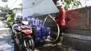 Pedagang mengisi jeriken dengan air bersih untuk segera didistribusikan kepada pelanggan di Kawasan Muara Angke, Jakarta, Kamis (28/5/2026). (Kapanlagi.com/Budy Santoso)