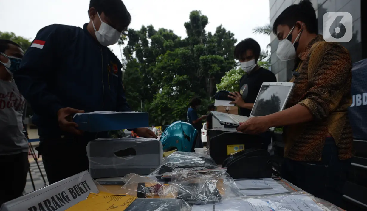 Petugas menata barang bukti dalam rilis tindak pidana pemalsuan surat hasil tes PCR dan swab antigen di Polda Metro Jaya, Selasa (13/7/2021). Petugas mengamankan barang bukti dokumen pembuatan surat swab antigen dan PCR palsu dengan tarif Rp170 - Rp 300 ribu. (merdeka.com/Imam Buhori)