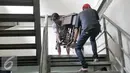 Dua orang pria memindahkan mesin jahit di Tempat Penampungan Sementara (TPS), Manggarai, Jakarta, Selasa (4/10). Pedagang Pasar Rumput mulai tempati kios TPS Pasar Jaya Manggarai. (Liputan6.com/Yoppy Renato)