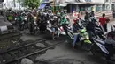 Pengendara motor melintas di perlintasan kereta api yang tidak berpalang pintu di kawasan Roxy, Jakarta, Rabu (21/3). Akhirnya antara warga dan petugas menyepakati untuk membuka celah selebar dua meter di lokasi tersebut. (Liputan6.com/Arya Manggala)