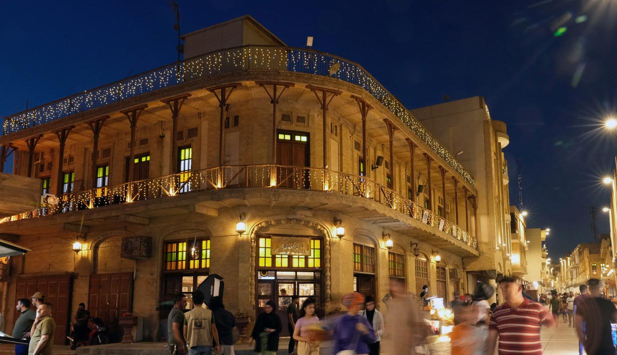 Warga Irak berjalan melalui pasar buku di Jalan Mutanabi Baghdad, Irak (18/5/2022). Jalan Al-Mutanabbi merupakan pusat jual beli buku yang bersejarah di Baghdad, sebuah jalan yang dipenuhi toko-toko buku dan lapak-lapak penjual buku. (AP Photo/Hadi Mizban)