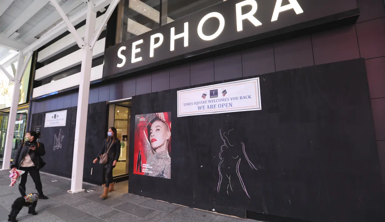 Pejalan kaki terlihat di depan sebuah toko yang dipasangi papan pelindung di Times Square di New York, Amerika Serikat pada 1 November 2020. Langkah itu dilakukan saat para peretail berupaya melindungi properti dari penjarahan atau kerusuhan lainnya dalam beberapa hari mendatang (Xinhua/Wang Ying)