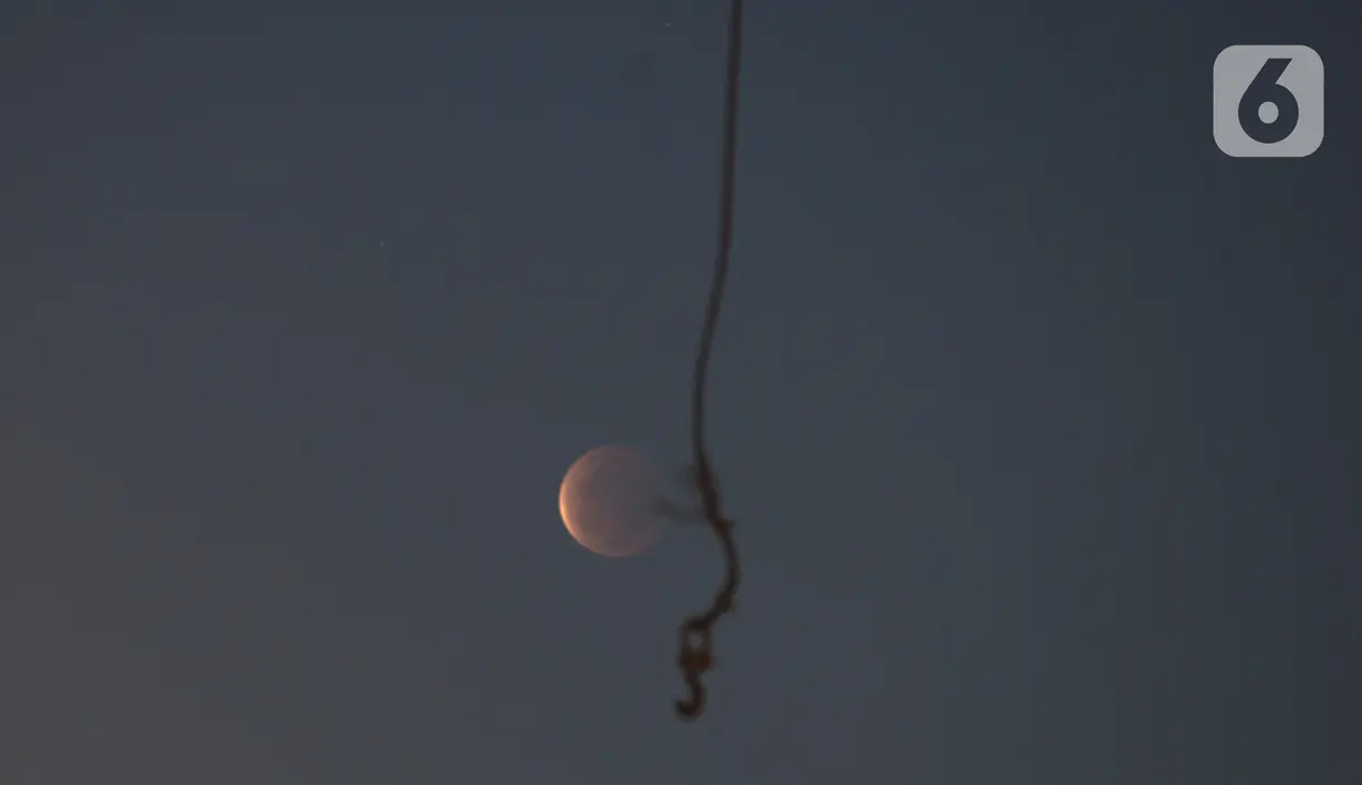 Gerhana bulan terlihat dari di Jalan Belah Kapal, Cilincing, Jakarta Utara pada Rabu (26/5/2021). Gerhana bulan yang disebut juga fenomena "Super Blood Moon" tersebut berlangsung sekitar lima jam lima menit dan dapat disaksikan dari seluruh Indonesia. (merdeka.com/Imam Buhori)