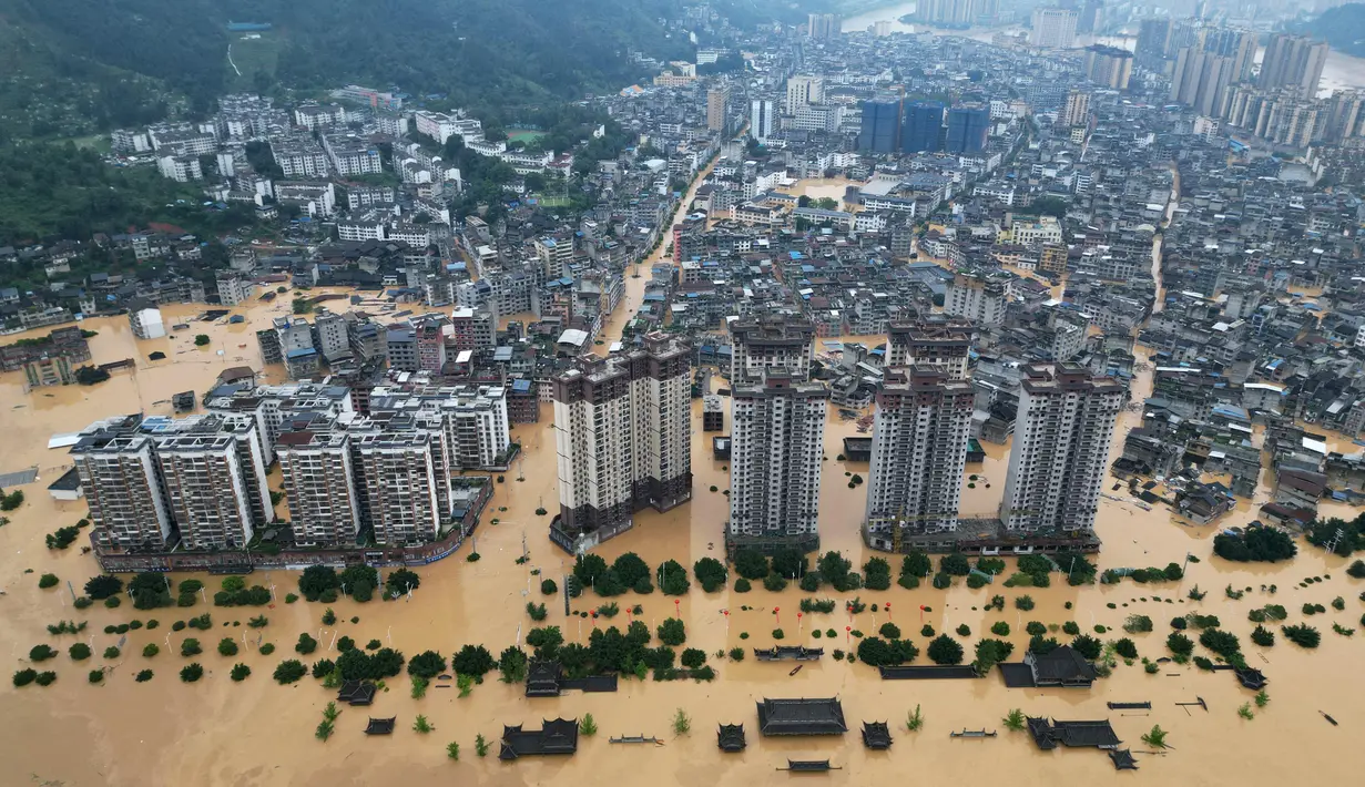 Tim penyelamat, termasuk petugas pemadam kebakaran dan sukarelawan, telah diterjunkan untuk melakukan upaya-upaya penyelamatan. Tampak foto udara yang menunjukkan bangunan-bangunan yang terendam banjir di Rongjiang, provinsi Guizhou barat daya China pada 24 Juni 2025. (AFP/China OUT)