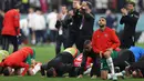 <p>Para pemain Maroko tetap bersujud syukur dan berterima kasih kepada penonton usai pertandingan melawan Prancis pada semifinal Piala Dunia 2022 di Stadion Al-Bayt di Al Khor, Doha, Kamis (15/12/2022). Maroko kalah dari Prancis 2-0 dan gagal melaju ke final Piala Dunia 2022. (AFP/ADRIAN DENNIS)</p>