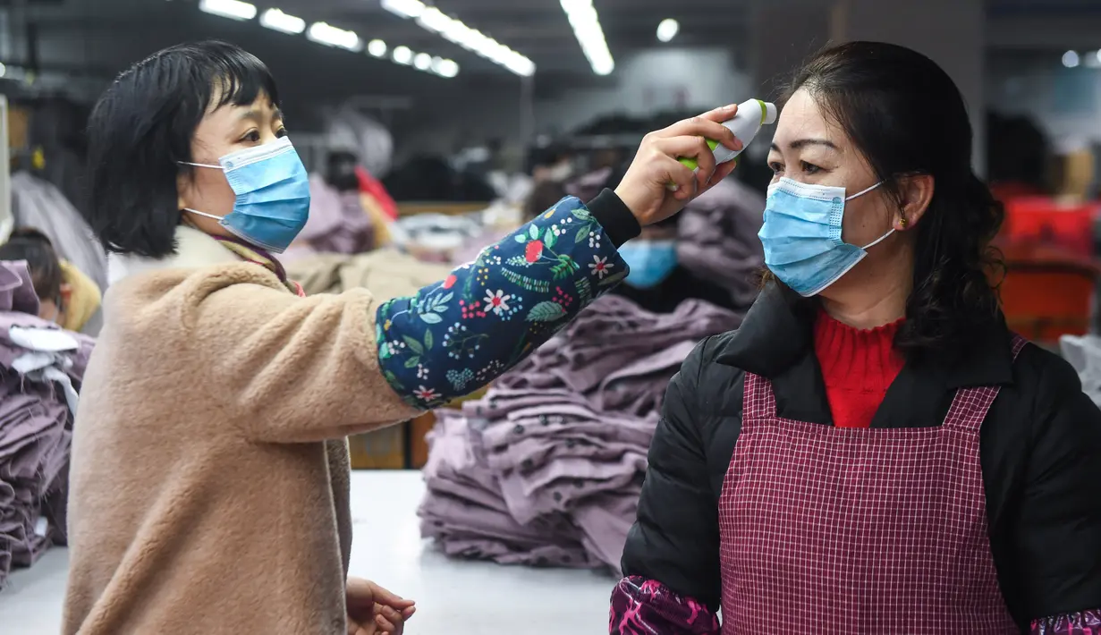Karyawan diukur suhu badannya di Hangzhou Jiefeng Garments Co. Ltd., Hangzhou, Provinsi Zhejiang, China, Rabu (12/2/2020). Di bawah arahan dan dukungan otoritas setempat, banyak perusahaan di Zhejiang kembali beroperasi setelah melakukan pencegahan dan pengendalian wabah virus corona. (Xinhua/Xu Yu)