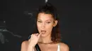 Model Bella Hadid merapikan lipstiknya selama promosi Magnum di Festival Film Cannes KE-71 di private beach, Cannes, Prancis selatan (10/5). Bella Hadid tampil cantik dan seksi dengan gaun putih minim dengan kalung di lehernya. (AP Photo/Arthur Mola)