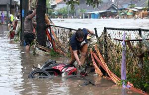 Tingginya intensitas hujan memicu sejumlah aliran sungai di Pulau Bali meluap, salah satunya aliran Tukad (Sungai) Badung di dekat Pasar Badung, Denpasar. (SONNY TUMBELAKA/AFP)