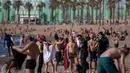 Petugas polisi meminta orang-orang untuk tidak duduk sambil berpatroli di pantai di Barcelona, Spanyol, Rabu, (20/5/2020). Berjemur dan berenang masih tidak diizinkan di pantai tersebut.  (AP Photo/Emilio Morenatti)