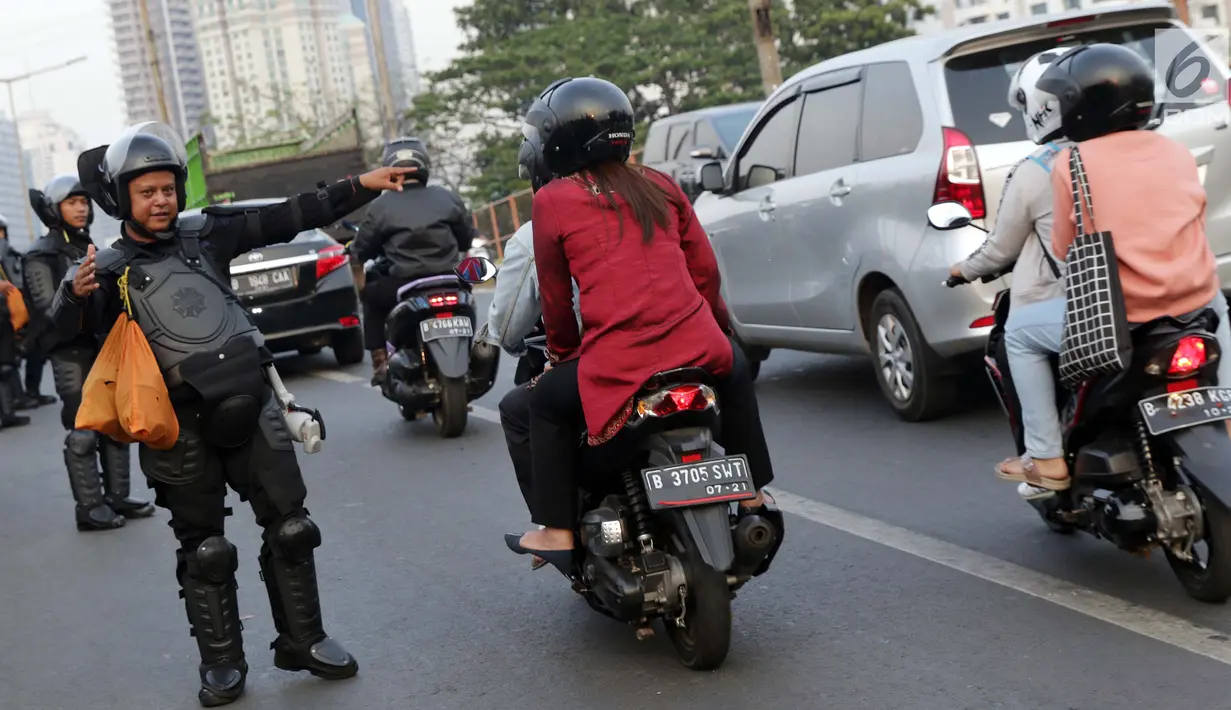 Personel Brimob mengatur arus lalu lintas yang tersendat akibat sejumlah pengendara dan warga berhenti menyaksikan aksi unjuk rasa yang dilakukan mahasiswa dari berbagai perguruan tinggi di sekitar Jembatan Layang Gerbang Pemuda, Jakarta, Selasa (1/10/2019). (Liputan6.com/Helmi Fithriansyah)