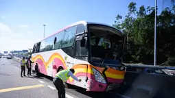 Polisi mengecek tempat kejadian kecelakaan bus dan taksi di Hong Kong (30/11). Bus tersebut dalam perjalanan ke bandara Hong Kong bertabrakan dengan taksi, kata polisi, dengan penumpang dilaporkan terlempar dari jendela bus. (AFP Photo/Anthony Wallace)