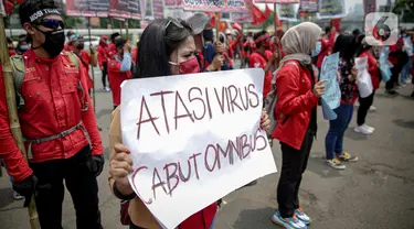 Massa buruh membawa poster saat menggelar unjuk rasa di depan Kompleks Gedung DPR/MPR, Jakarta, Selasa (17/11/2020). Buruh kembali menggelar aksi lanjutan menuntut pemerintah dan DPR untuk mencabut Omnibus Law Undang-Undang Cipta Kerja. (Liputan6.com/Faizal Fanani)