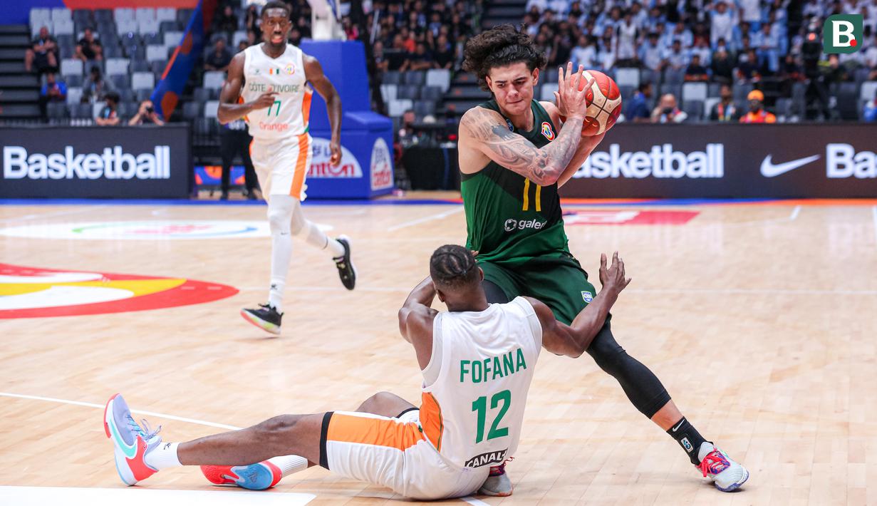 Pebasket Brasil, Gui Santos (kanan) berusaha melewati pebasket Pantai Gading, Vafessa Fofana yang sedang terjatuh pada laga ketiga Grup G Piala Dunia FIBA 2023 melawan Pantai Gading di Indonesia Arena, Senayan, Jakarta, Rabu (30/08/2023). Brasil menang dengan skor 89-77. (Bola.com/Bagaskara Lazuardi)