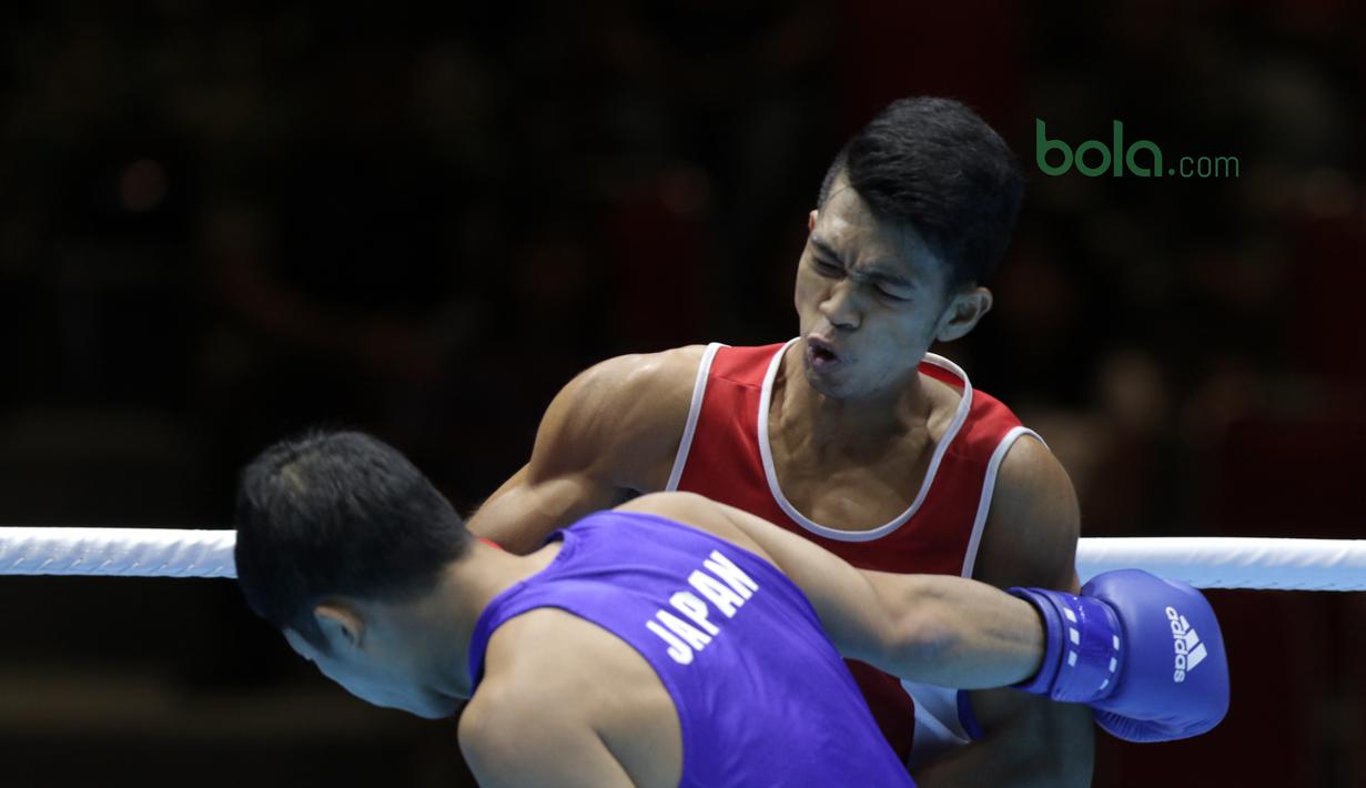 Ekspresi Grece Savon Simangunsong (Merah) saat memukul lawannya Hiroaki Kinjo pada semifinal Test Event Asian Games 2018 kelas Welter di Kemayoran, Jakarta (14/2/2018). Simangunsong menang dengan skor 3-2. (Bola.com/Nick Hanoatubun)